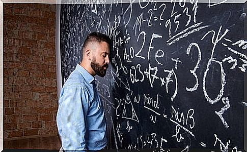 Tired professor leans his head on the blackboard