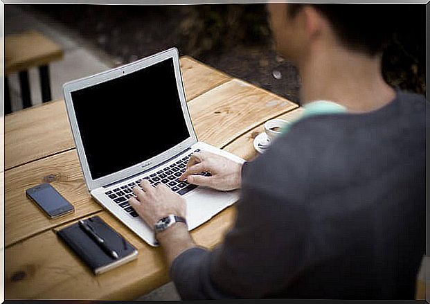 Man at pc with smartphone beside