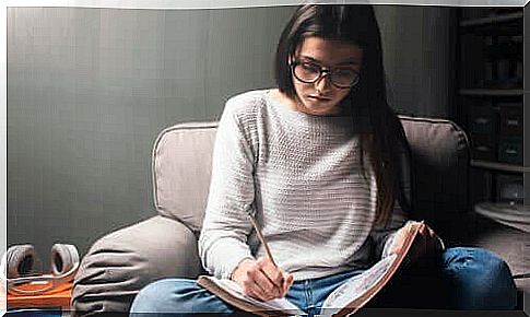 Girl with glasses studying sitting on the armchair