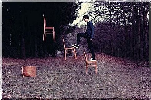 Boy climbing on chairs suspended in the air