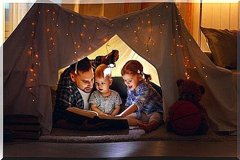 Dad reading with his children inside a tent