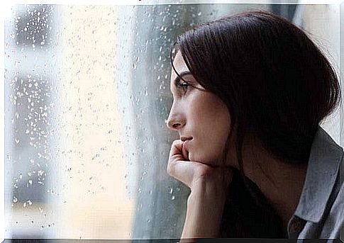 A sad woman looking out the window.