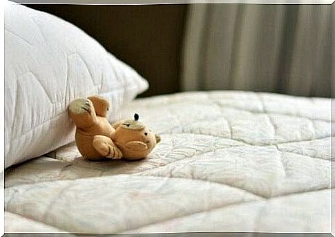 Teddy bear on a bed.