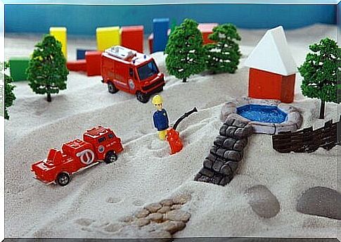 Sand with toy firefighters on top