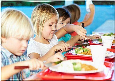 Children eating vegetables in the school canteen