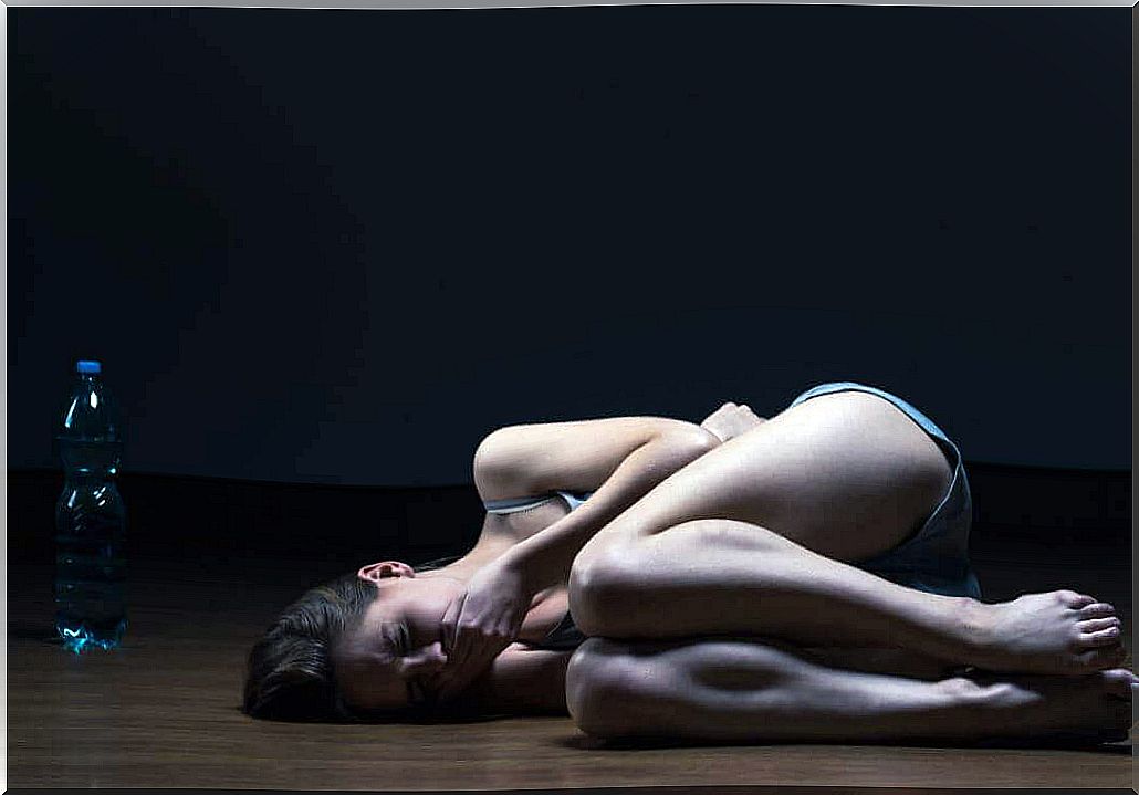 Woman lying on the ground on black background