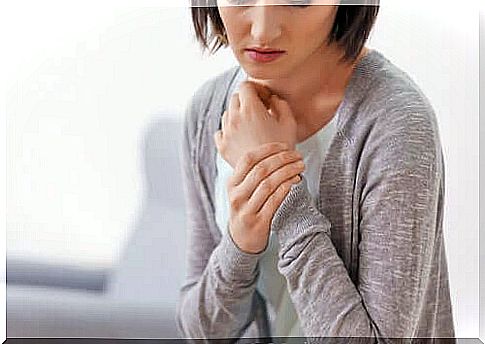 Woman reflecting while holding her wrist