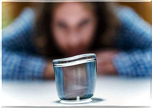 Woman trying to move a glass with the strength of her mind.