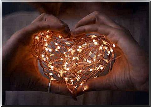 Hand with heart of lights.